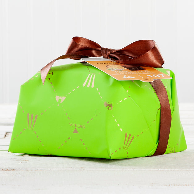 A green rectangular panettone with brown ribbon and decorative patterns, placed on a white surface.
